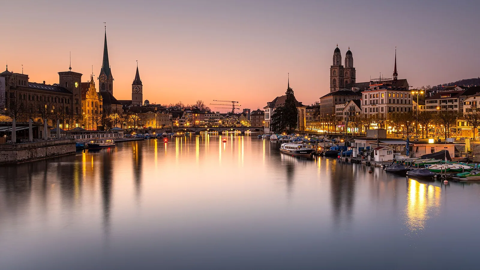 Zürich ob reki Limmat v večernem mraku